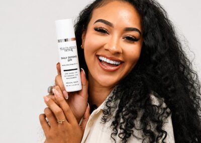 Woman holding Beauty Health SkinRx Daily Defense SPF sunscreen